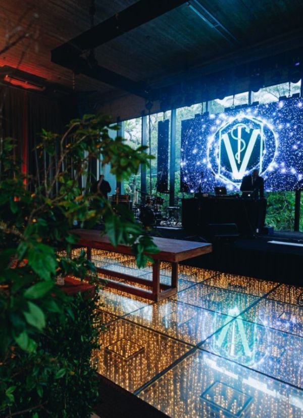 Pista de dança iluminada com plantas e telão
