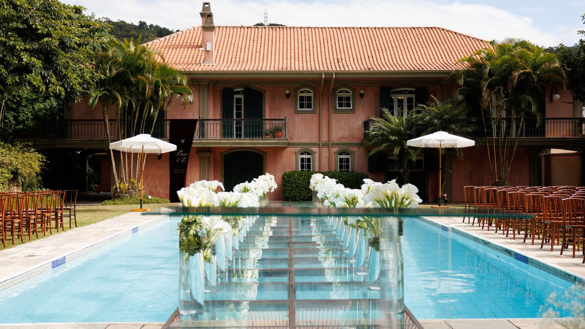 Passarela sobre a piscina com o casarão ao fundo