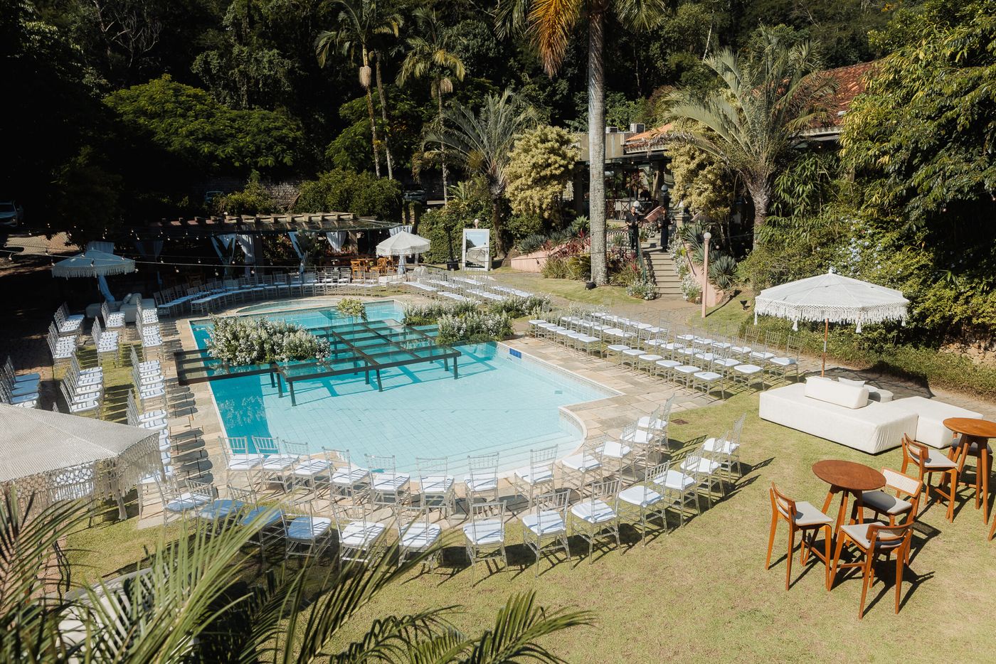 Piscina com cadeiras para cerimônia e ombrelones