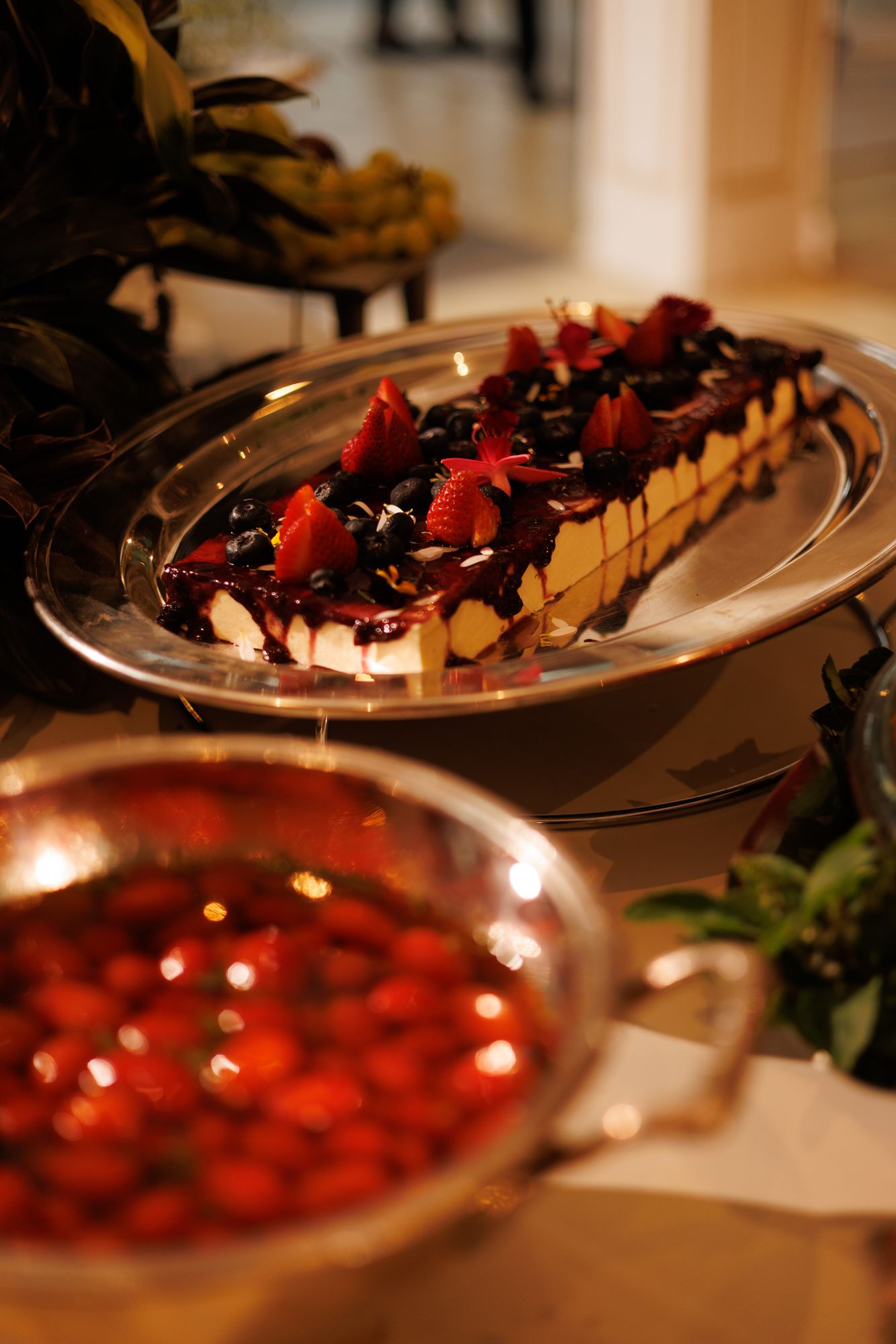 Torta com frutas vermelhas, morangos e mirtilos em travessa de prata